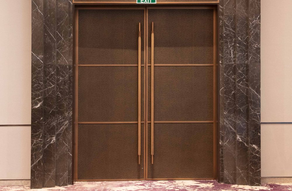 Bronze bonded metal double doors in a marble lobby