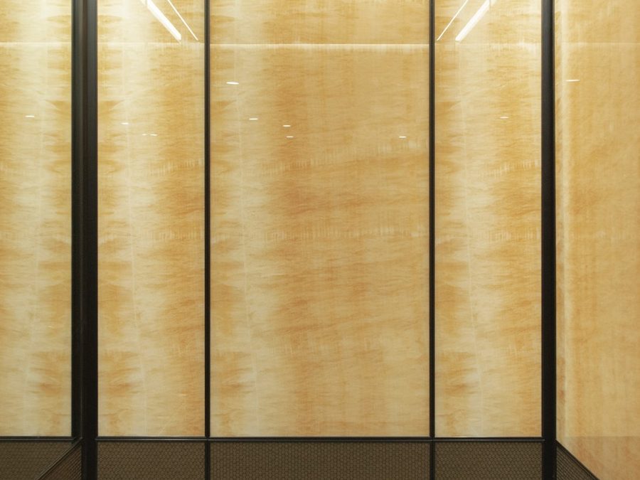 Elevator cabin finished in gold-toned metal