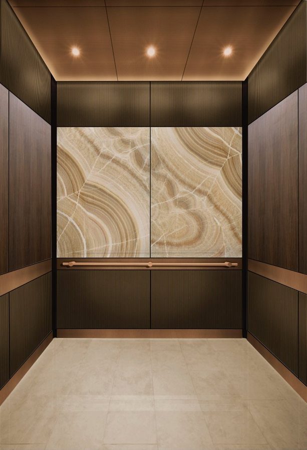 Lift cabin finished in bronze metal with a backlit onyx panel